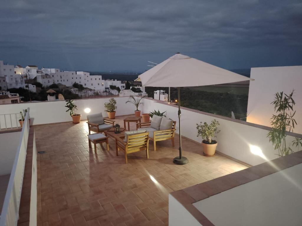 Rooftop terrace of Casa Arbonaida at dusk with seating and views over Vejer